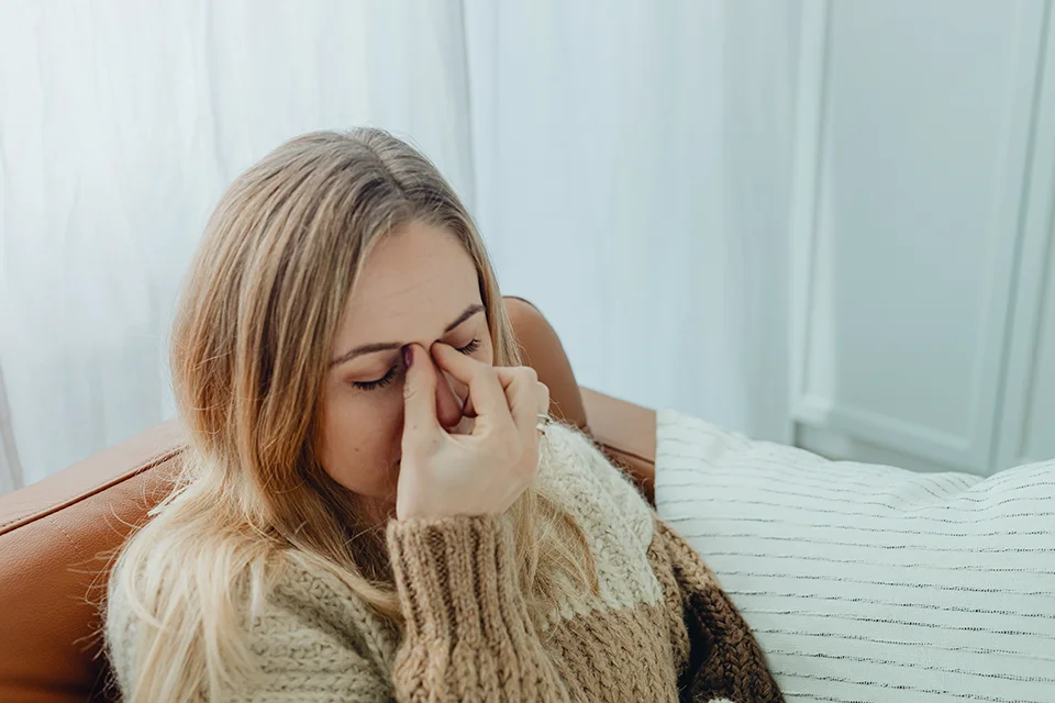Imagen de una chica tocando sus ojos debido al dolor causado por la sinusitis