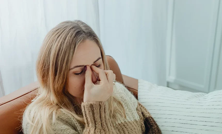 Imagen de una chica tocando sus ojos debido al dolor causado por la sinusitis